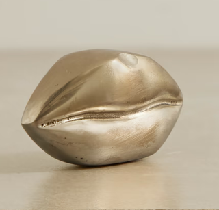 A brass lip shaped ornament