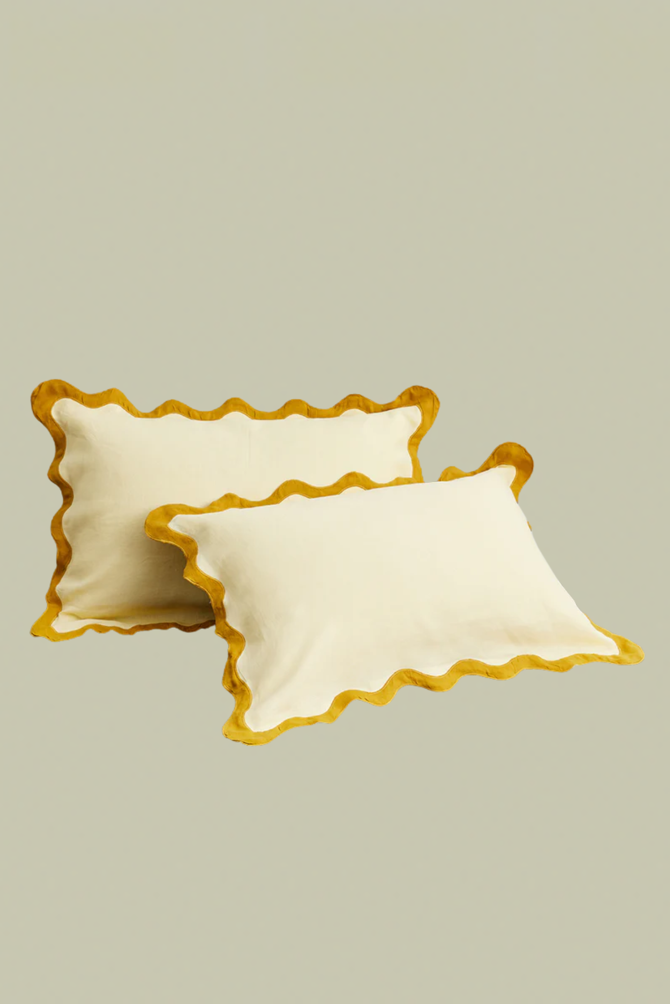 Two yellow pillowcases with orange scalloped piping