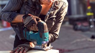 Carpenter using blue jigsaw