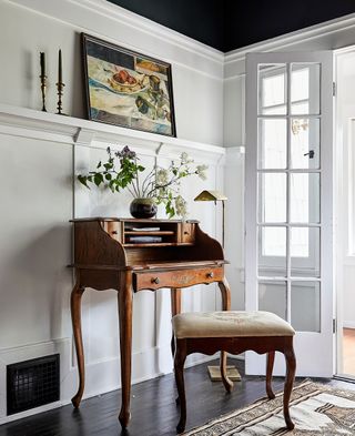 wooden bureau in library with white walls