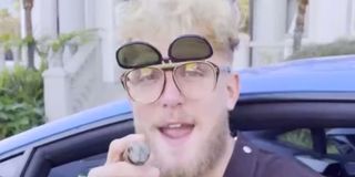 Jake Paul smoking a cigar and wearing ridiculous sunglasses.