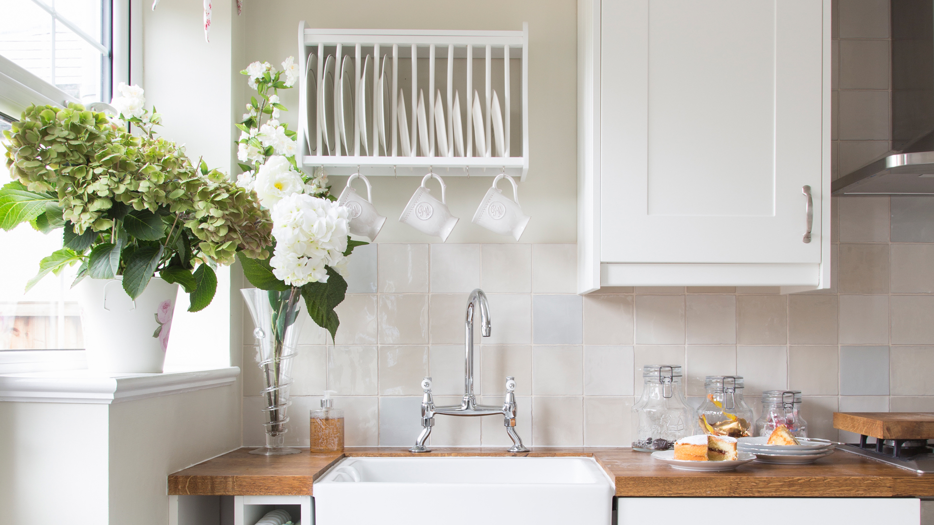 cream kitchen with plate rack wall-mounted above the sink