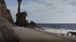 A still from Planet of the Apes where the Statue of Liberty is visible above the waves