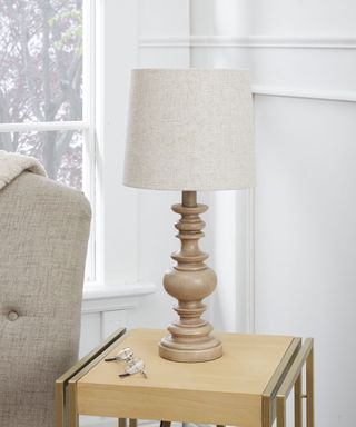 Cream and wooden table lamp on light wooden side table