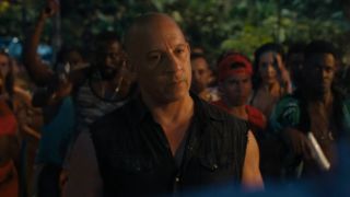Vin Diesel stands among a crowd with an angry expression in Fast X.