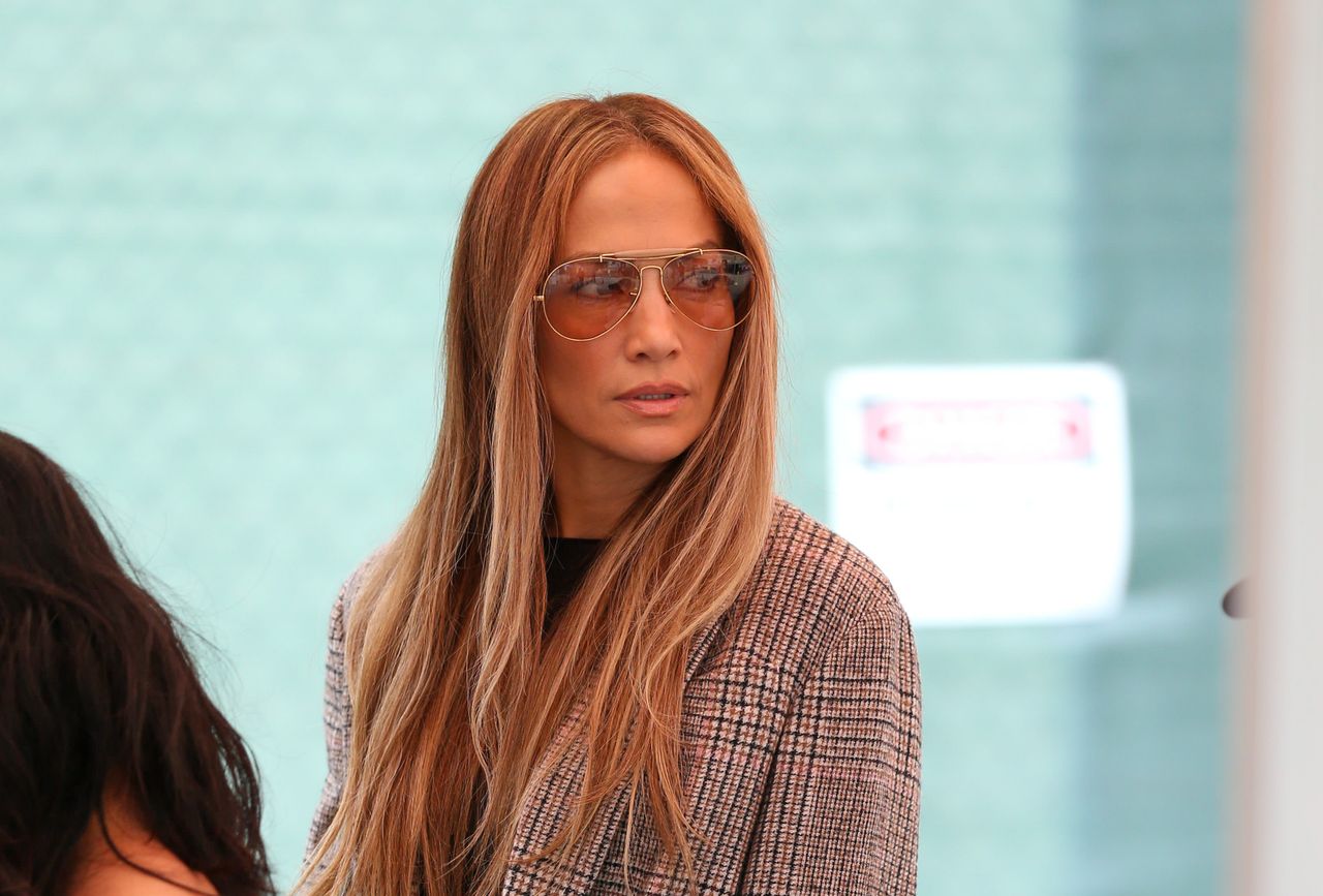 Jennifer Lopez walking in Los Angeles wearing a plaid blazer and wide leg jeans