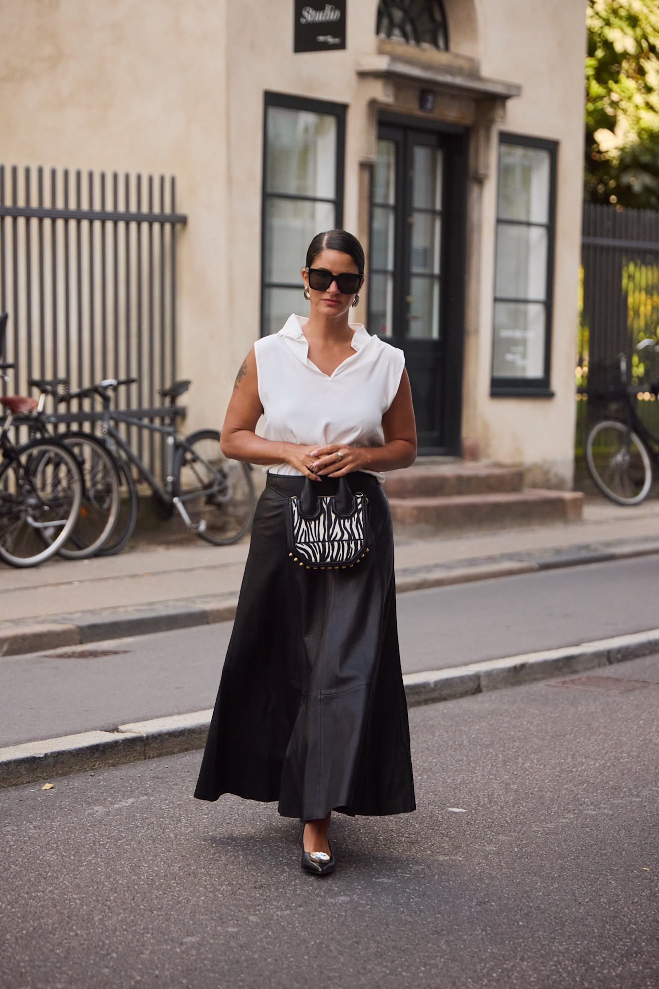 woman wearing a black skirt and a white polo top in Copenhagen.