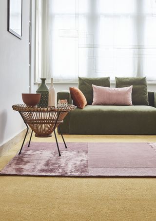 living room with green sofa and ochre carpet