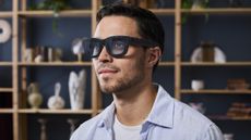 Press photo of a man wearing the Meta Project Orion AR glasses.