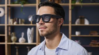 Press photo of a man wearing the Meta Project Orion AR glasses.