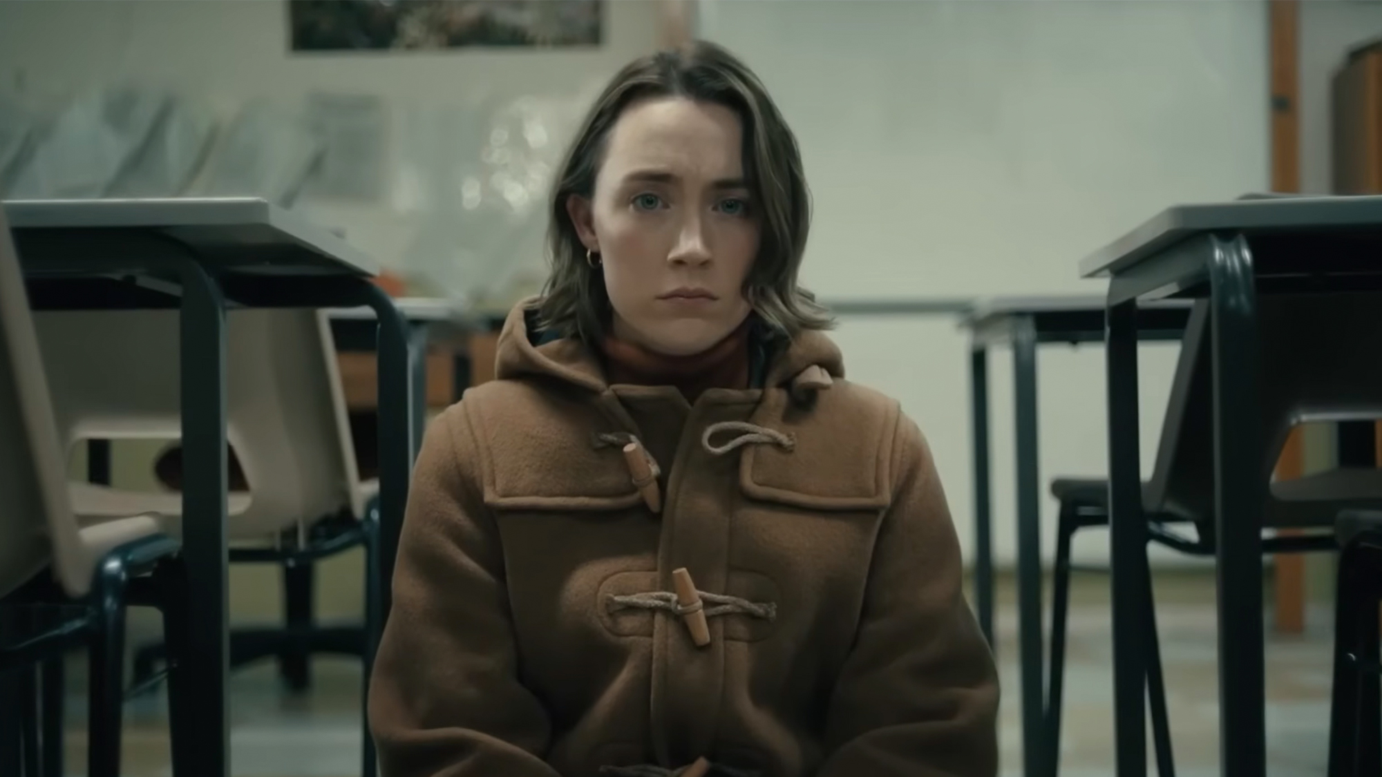 Saoirse Ronan in a brown jacket, looking somber in Bad Apples