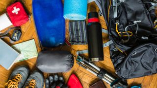 Hiking gear and backpack laid out on the floor