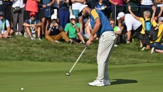 Jon Rahm putts on the 18th green during his Ryder Cup singles match against Scottie Scheffler
