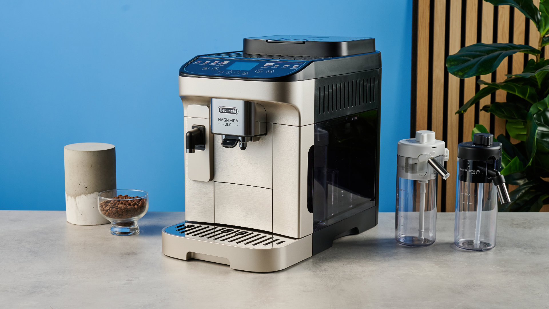 the de'longhi magnifica duo photographed with the blue tom's guide background showing the milk carafe and coffee machine screen