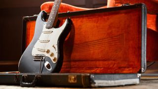 A vintage Fender Stratocaster sitting up in it's case