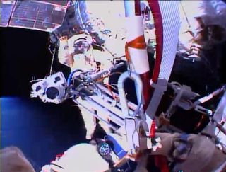 Russian cosmonaut Sergey Ryazanskiy waves as he awaits the Olympic torch in this view from cosmonaut Oleg Kotov during a Nov. 9, 2013 spacewalk outside the International Space Station. The spacewalk was the first time an Olympic torch ever was taken outsi