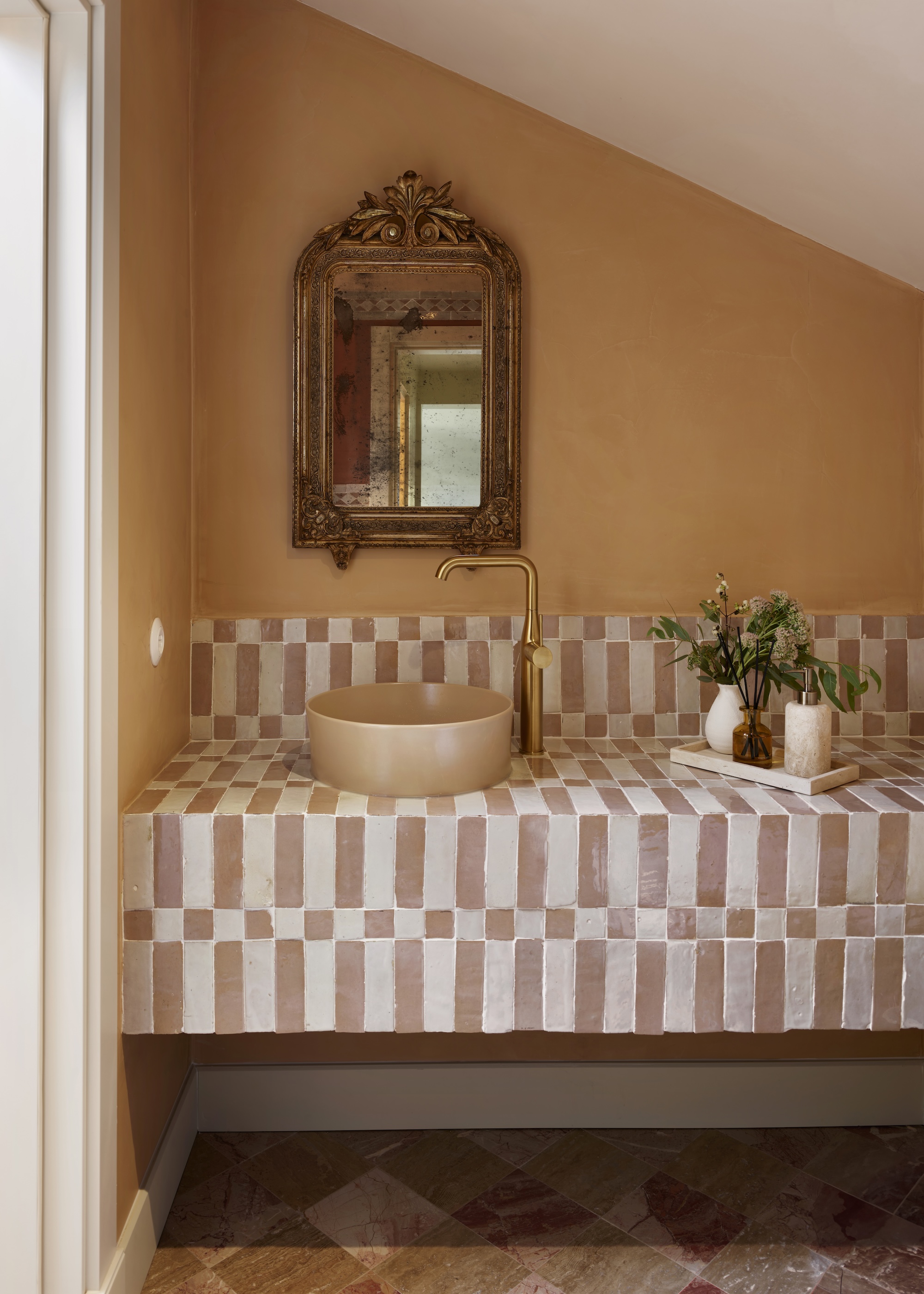 A tiled basin area showing how to use feature tiles well. Shown with terracotta painted walls and vintage accessories