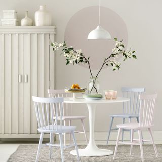 white dining space with pastel wooden chairs and tulip table