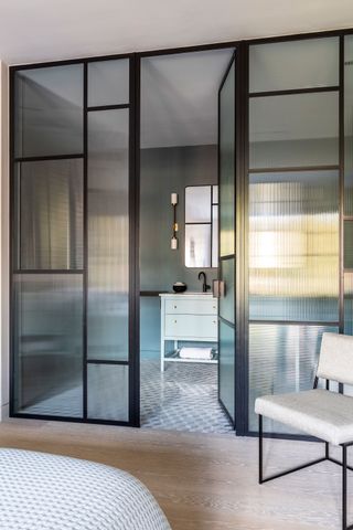 an ensuite bathroom with a glass wall