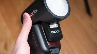 Godox V1Pro flashgun held in a hand