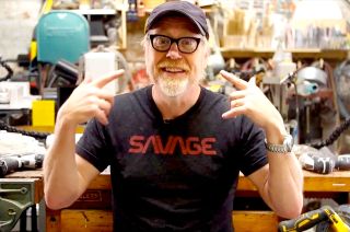 Adam Savage wearing a shirt with his name in the style of NASA's retro logotype, the "worm."