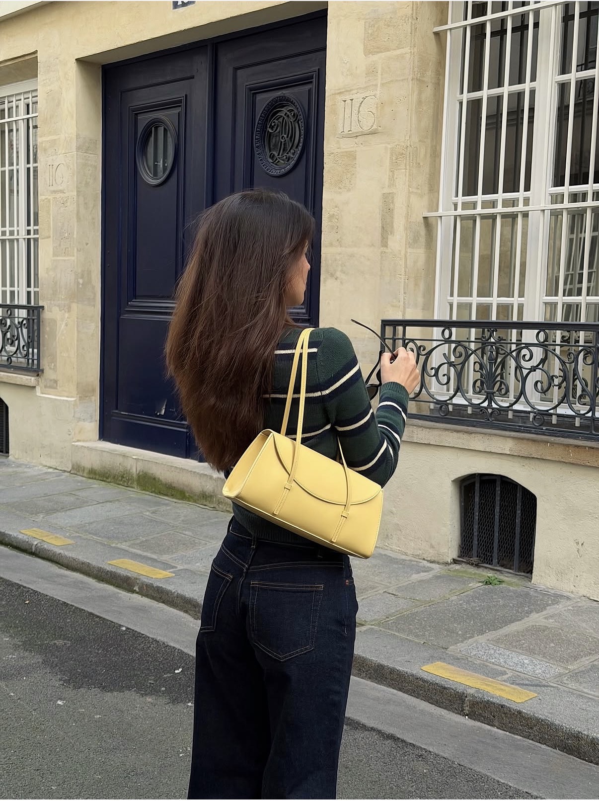 Tamara Mori wears a yellow handbag in Paris