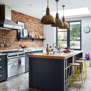 kitchen with facebrick wall and hanging pendant lights with brass lampshades