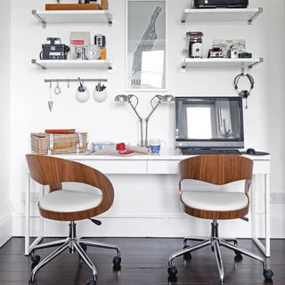 home office with white wall and desk with computer and chair with shelves