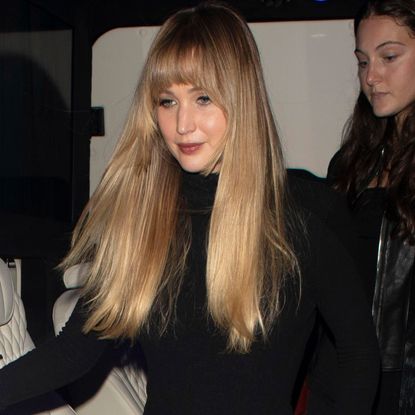 Jennifer Lawrence paired a butter yellow velvet maxi skirt with a matching drawstring bag and a black turtleneck in London