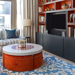 living room colour schemes, orange and blue apartment living room, blue patterned rug, bespoke bookcase