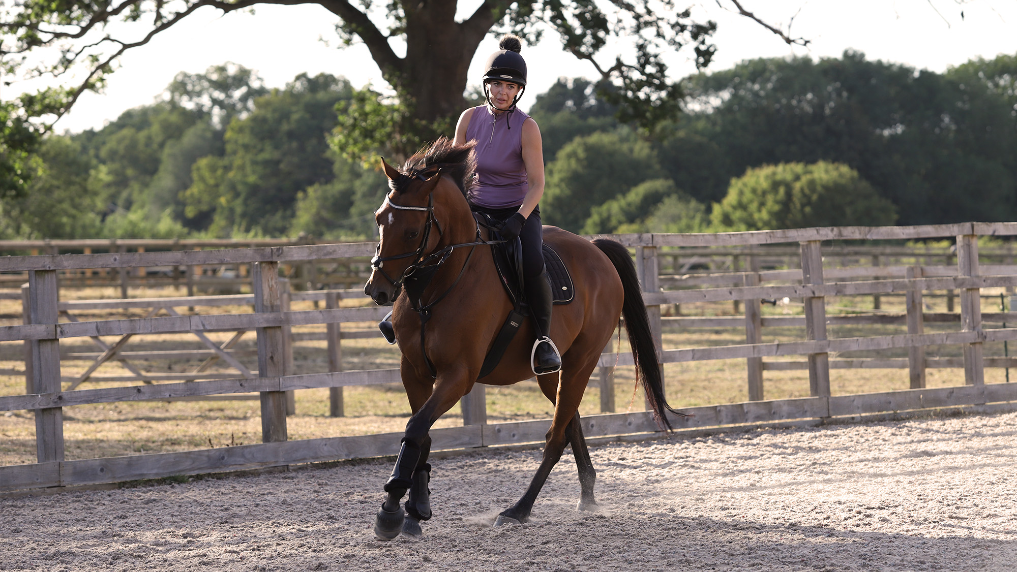 Woman cantering bay horse on a circle