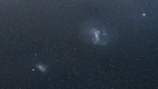 A starry night sky with two glowing blobs, one bigger than the other.
