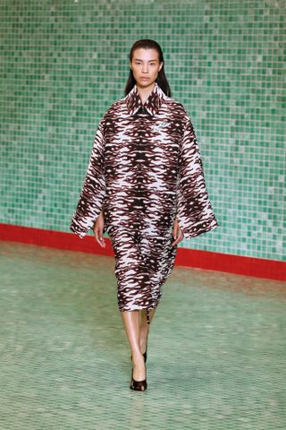 a model wears a printed coat on the runway at Tory Burch S/S 25