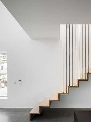 Wooden staircase suspended from ceiling with steel rods