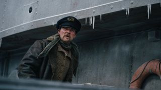 A still from the movie Arctic Convoy, a new Hulu movie for December, of a character walking along the edge of a boat