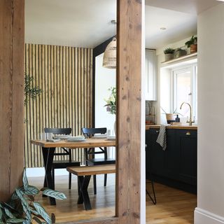 Kitchen with wooden accents and wall panelling, dining table, mirror