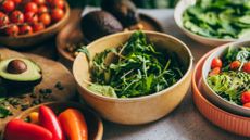 Collection of unprocessed foods, including rocket, avocados, tomatoes, and peppers