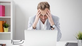 Stressed out person who suspects laptop is infected with malware