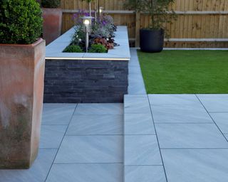raised garden bed at the edge of a paved patio