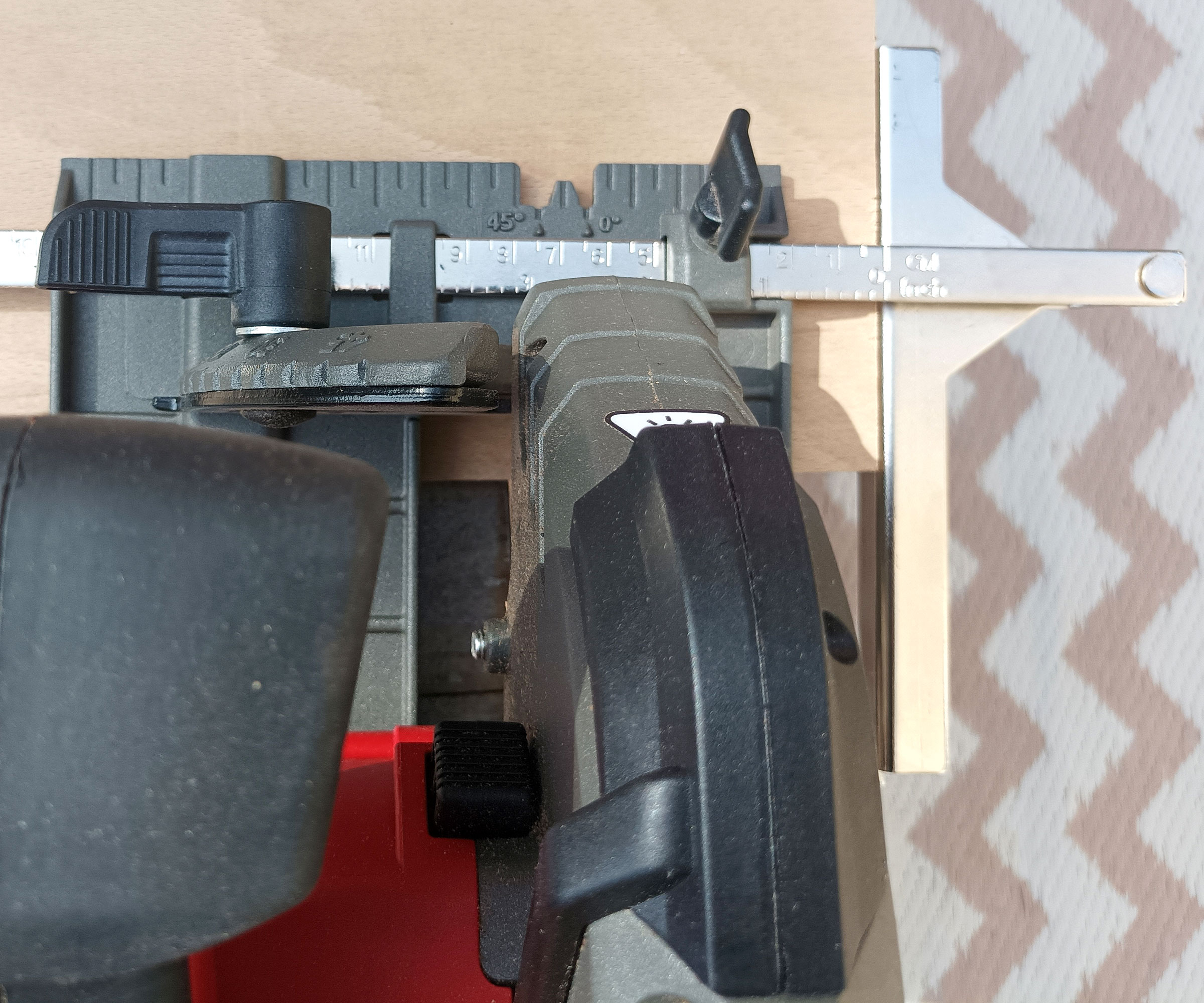 Top down image of Einhell circular saw with chrome parallel stop attached cutting plywood