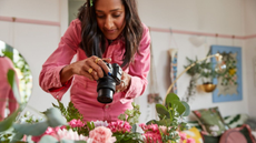 Woman holding a Canon camera taking a photo of plants