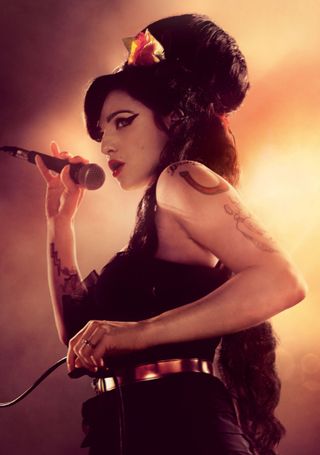 Marisa Abela as Amy Winehouse singing on stage with her hair up in the iconic bouffant in 'Back to Black'