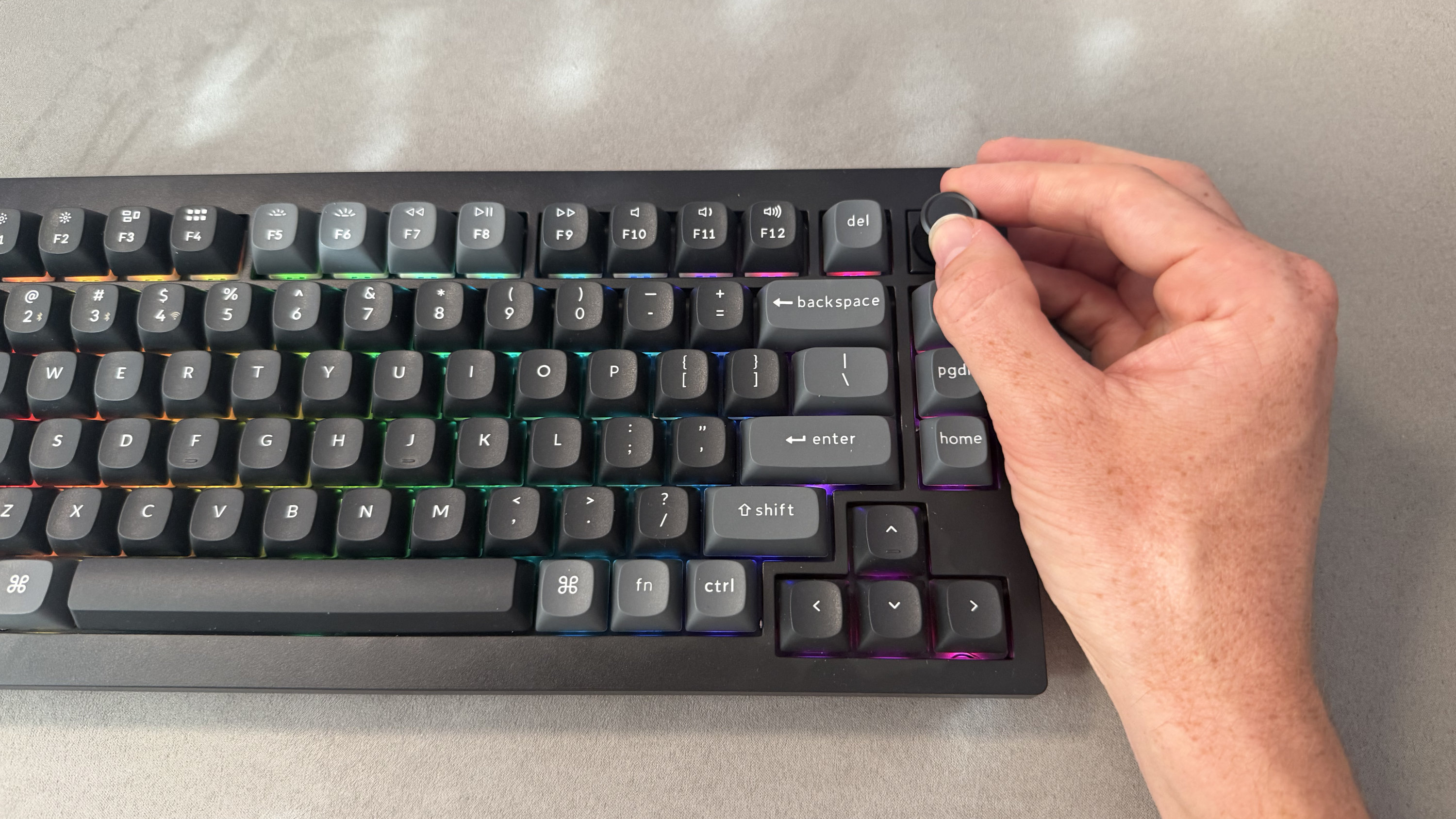 A man's hand turning the adjustable knob on the Keychron V1 Ultra 8K.