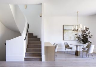 View of white minimalist dining area and spiral staircase