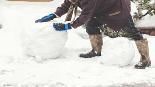 Image of a man rolling a large snowball