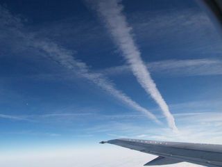 airplane flying below contrails