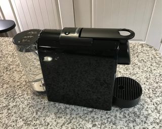 Nespresso Essenza Mini coffee maker with filled water tank on granite worktop