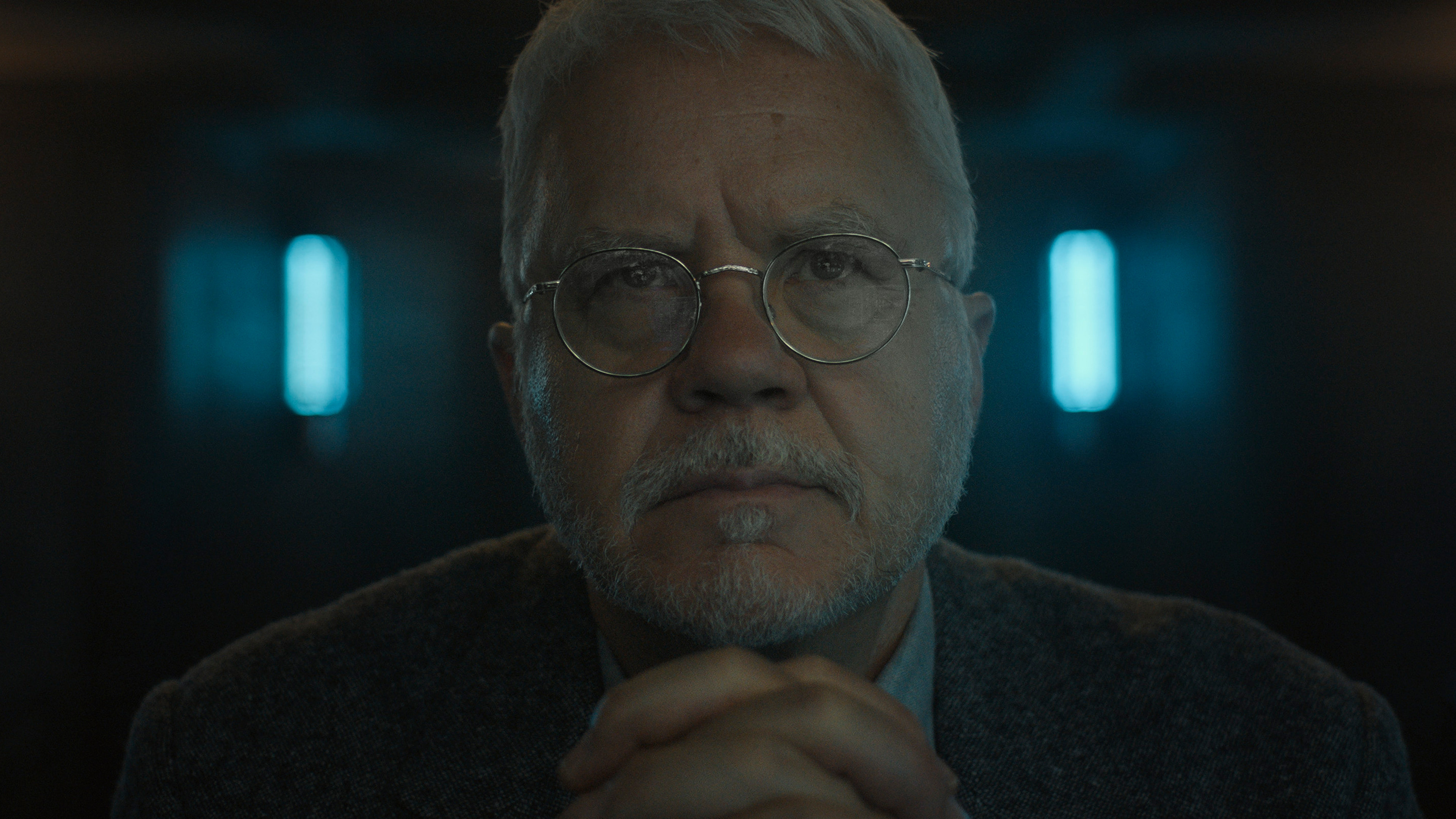 A bearded man with glasses stares into a screen