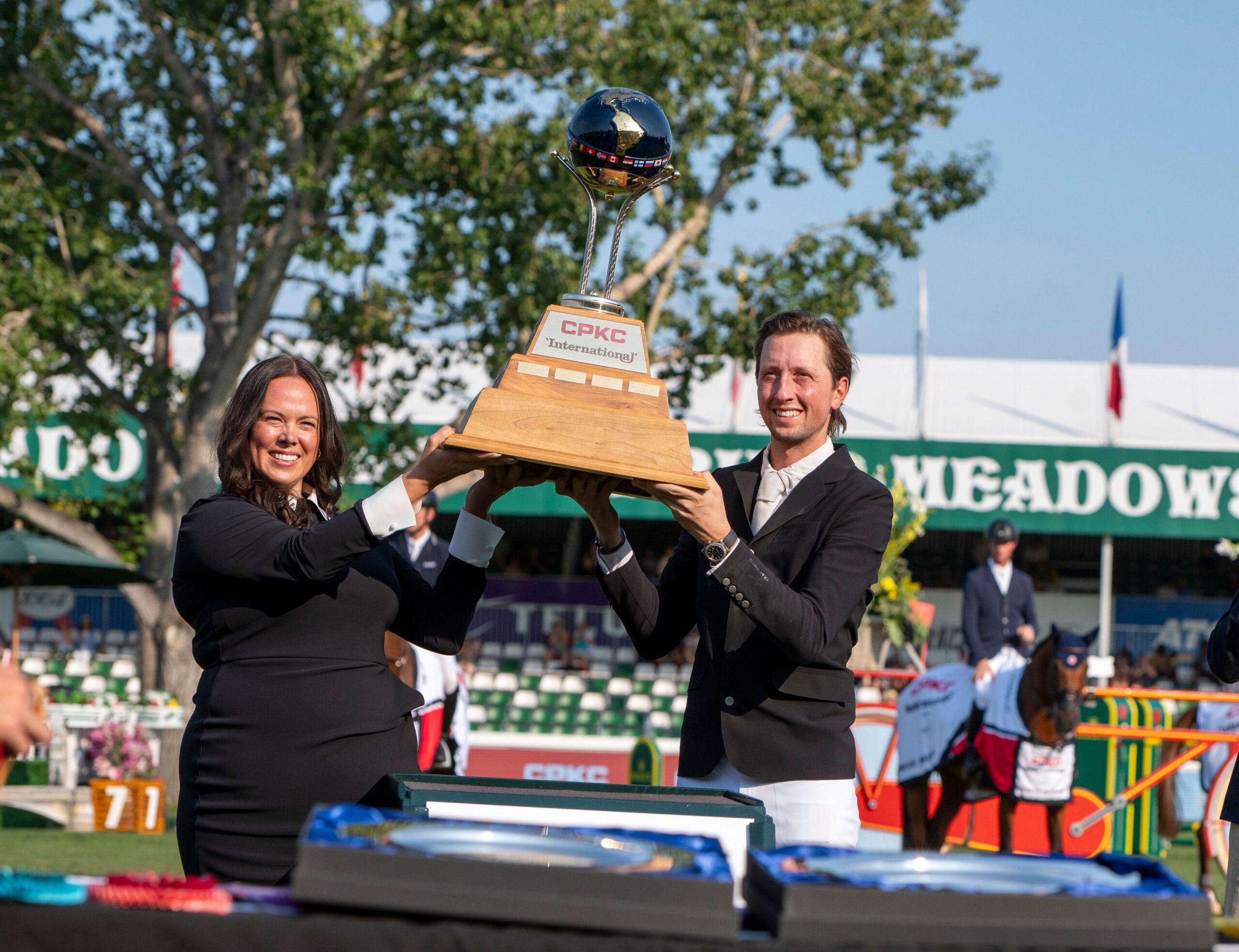 Martin Fuchs lifts the CPKC International trophy presented by Rolex for winning the grand prix at the Spruce Meadows Masters.