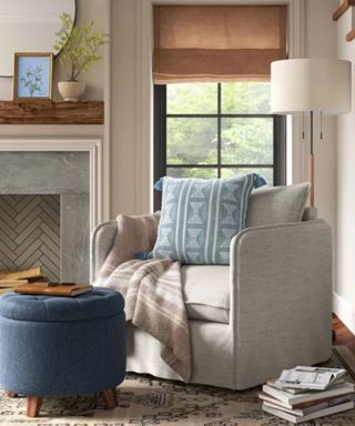 A gray living room chair next to a fireplace and window